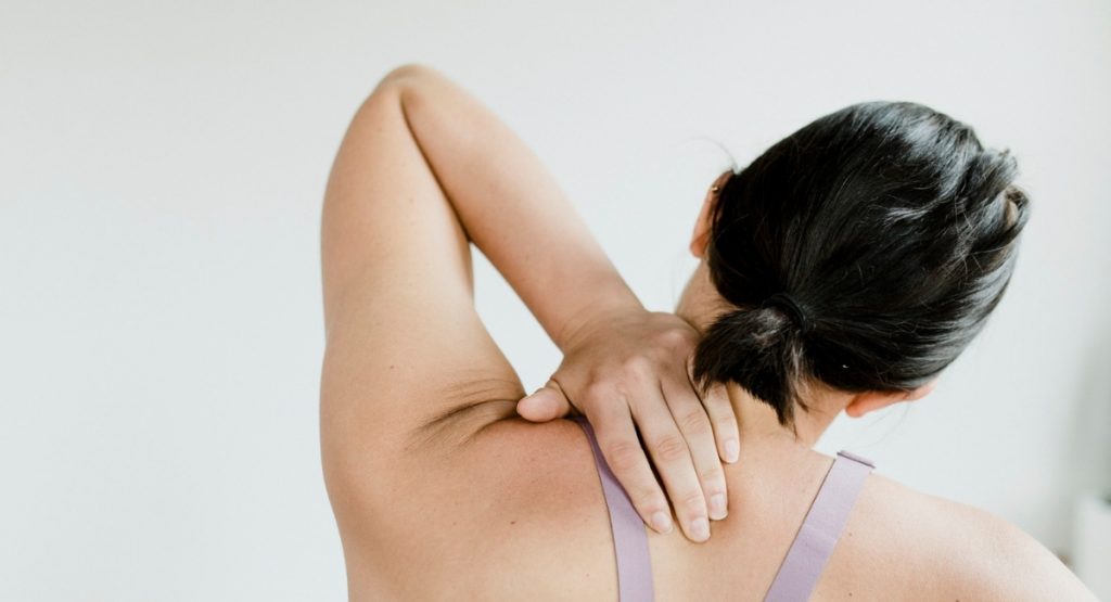 5 ασκήσεις για να αποφύγεις τον πόνο στην πλάτη στο γραφείο . Η εικόνα δείχνει ένα άτομο να τεντώνει τον αυχένα του προς τα δεξιά (freepik.com)